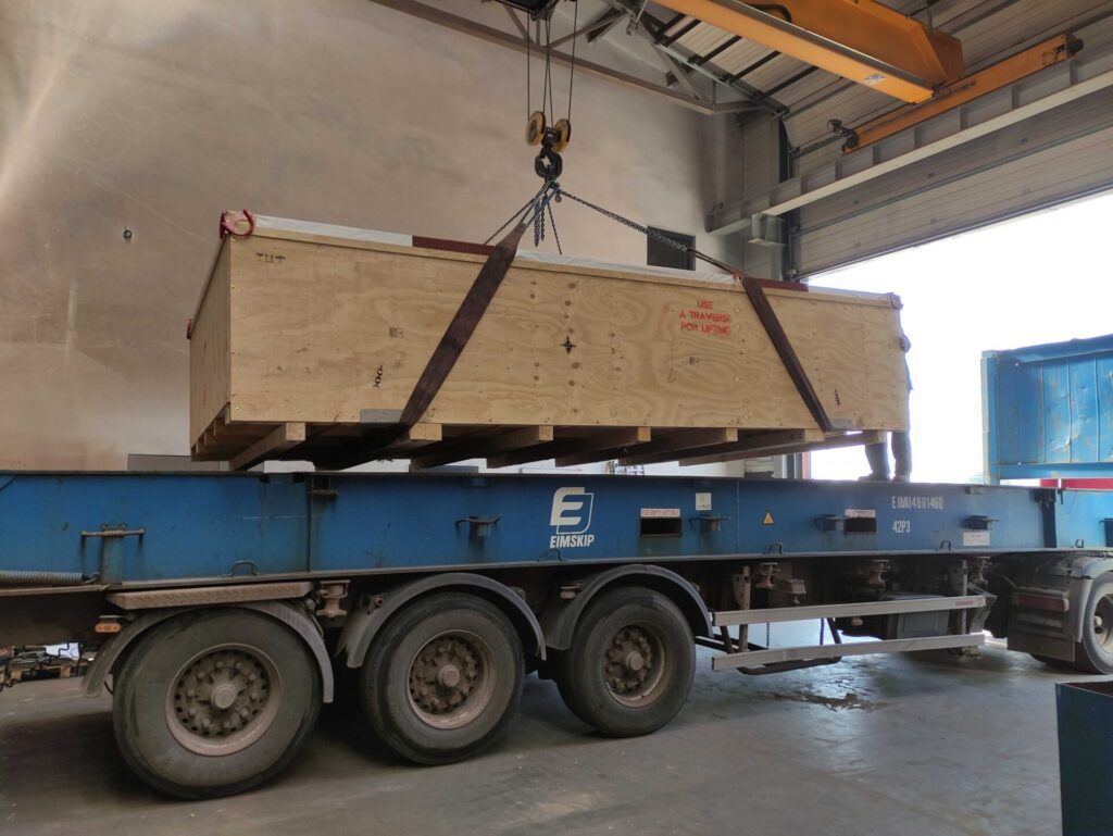 załadunek skrzyni transportowej na kontener flat rack do transportu morskiego